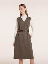 A woman wears a brown vintage dress.